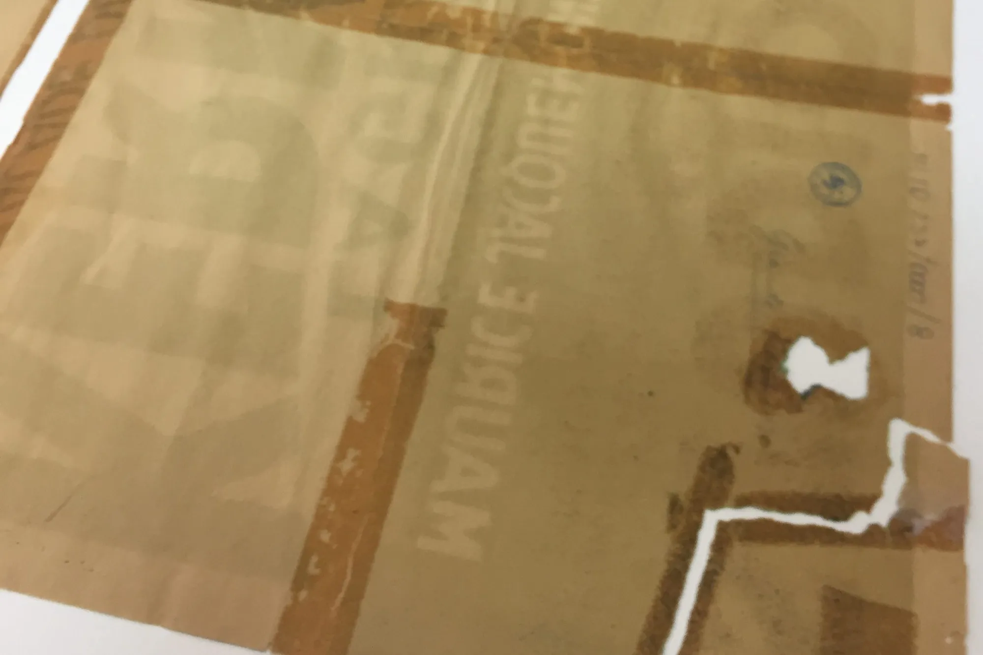 Retrait d'un ruban adhésif ancien à la spatule sur une feuille de papier